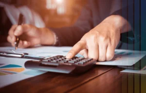 Man in suit calculating and writing reports symbolizing accounting support offered by Cerity Global