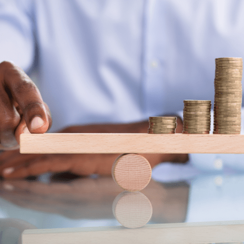 Cerity Global illustrating balanced financial management with stacked coins on a wooden scale, symbolizing accurate accounting and cost control in global operations